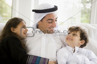 A Middle Eastern man with his children