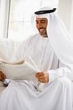 A Middle Eastern man reading a newspaper