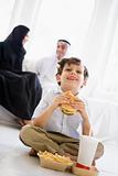 A Middle Eastern boy enjoying a fast food burger meal