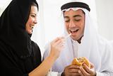 A Middle Eastern couple sharing a fast food meal
