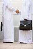 Two Middle Eastern businessmen holding briefcases