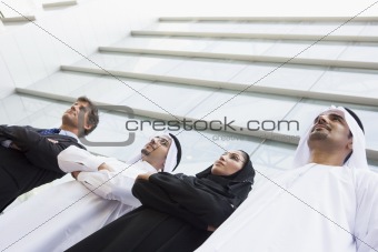 Middle Eastern and Caucasian business workers standing outside a