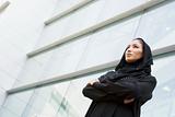 A Middle Eastern businesswoman standing outside an office block