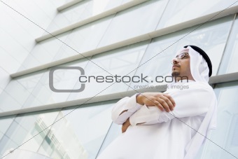 A Middle Eastern businessman standing outside an office block