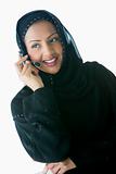 A Middle Eastern businesswoman talking with headphones