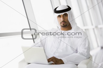 A Middle Eastern businessman sitting with a laptop