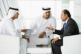 Three Middle Eastern men talking at a business meeting