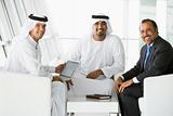 Three Middle Eastern men talking at a business meeting