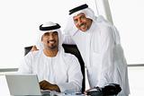 Two Middle Eastern businessmen beside a laptop