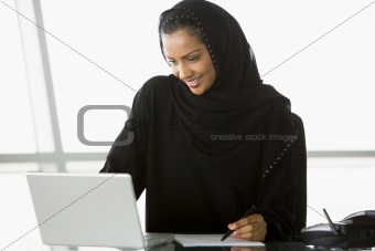 A Middle Eastern businesswoman using a laptop