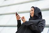 A Middle Eastern businesswoman using a PDA