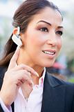 Businesswoman using bluetooth earpiece 
