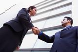 Two businessmen shaking hands outside office building