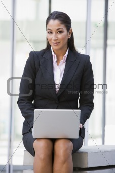Businesswoman using laptop computer outside