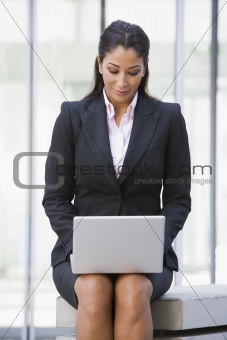 Businesswoman using laptop computer outside