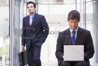 Businessman using laptop computer outside