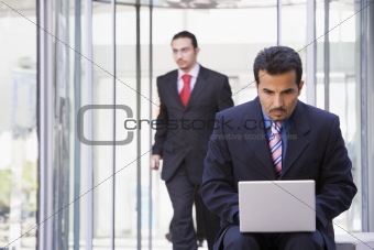 Businessman using laptop outside