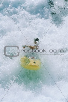 Young man kayaking in rapids