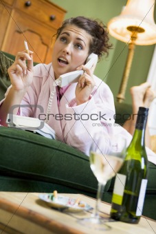 A young woman in her pyjamas on the phone and smoking