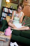 A young woman sitting on her couch drinking tea
