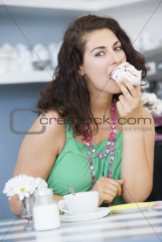 A young woman eating cake in a cafe
