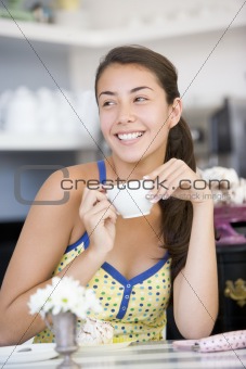 A young woman drinking tea in a cafe