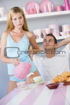 Annoyed woman serving boyfriend tea 