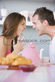 A young couple arguing at the breakfast table