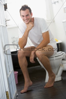 A young man sitting in the bathroom