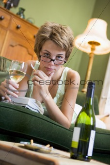 A young woman in her pyjamas drinking wine and smoking