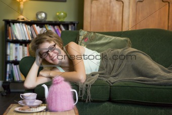 A young woman lying on her couch