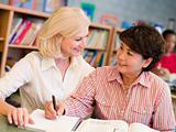 Tutor assisting mature student in library
