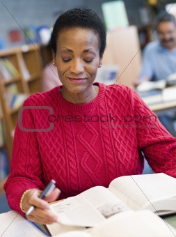 Mature female student studying in library
