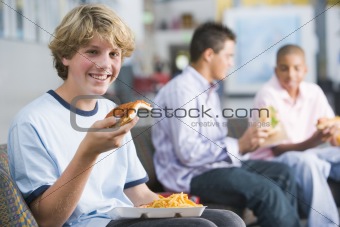 Teenage boys enjoying fast food lunches together