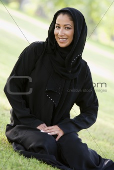 A Middle Eastern woman sitting in a park
