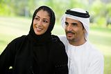 A Middle Eastern couple sitting in a park