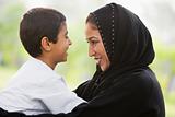 A Middle Eastern woman and her son sitting in a park