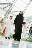 A Middle Eastern woman and her son in a shopping mall