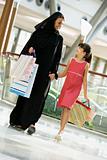A Middle Eastern woman with a girl in a shopping mall