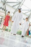A Middle Eastern man with two children in a shopping mall