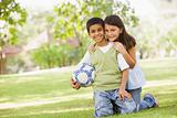 Two children playing football in park