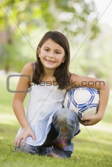 Girl in park holding football