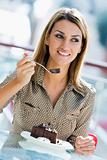 Woman eating chocolate cake in cafe