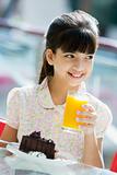 Young girl drinking orange juice in cafe