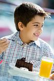 Boy eating chocolate cake in cafe