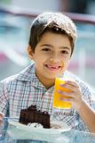 Boy drinking orange juice in cafe