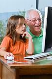 grandfather and granddaughter with computer