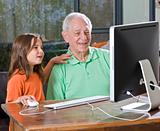 grandfather and granddaughter with computer
