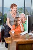grandparents and granddaughter with computer