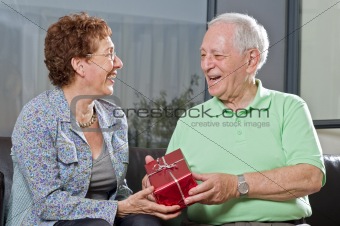 senior couple giving gift